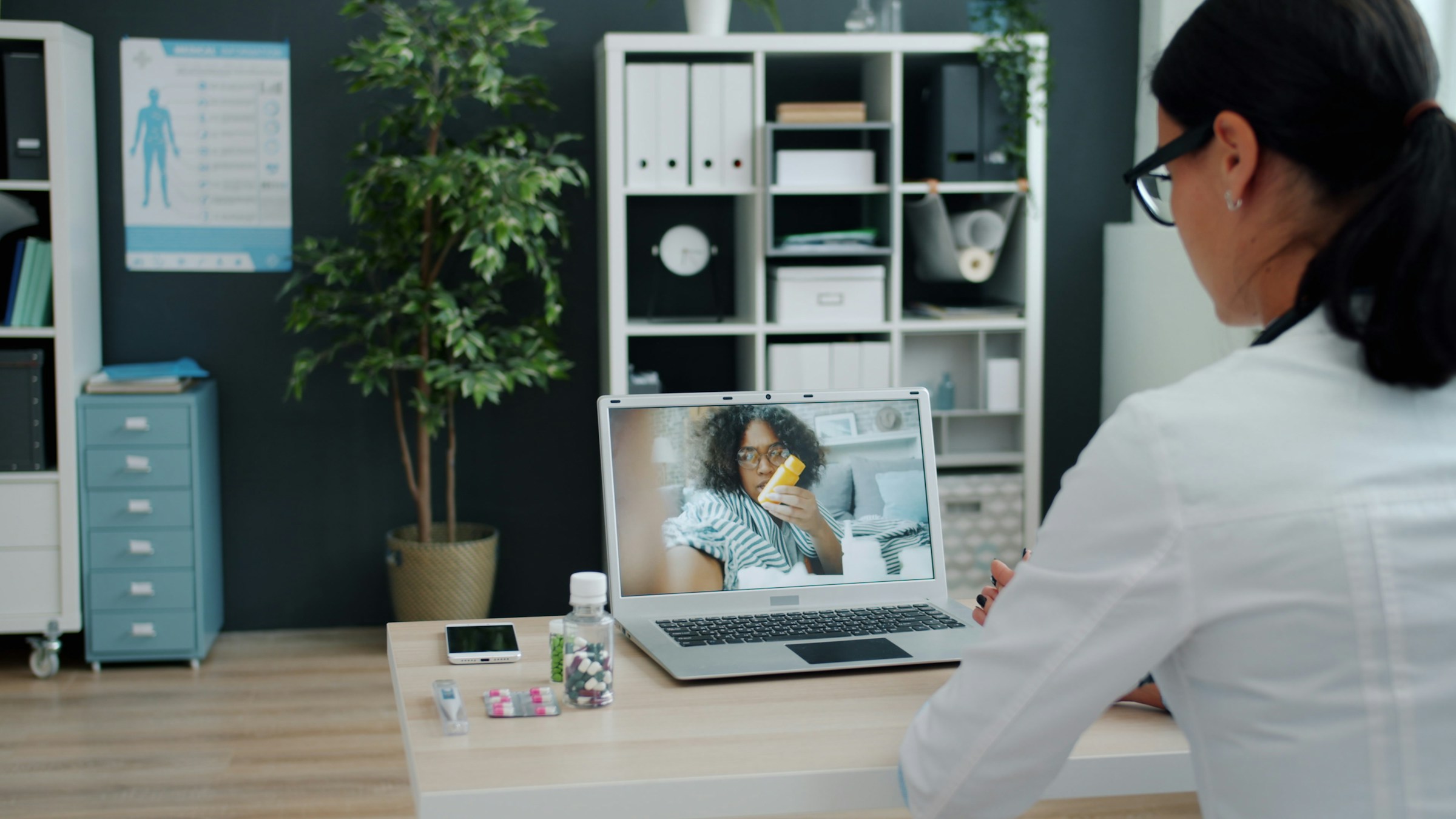 Female doctor conducting a teleconsultation with a female patient through a computer screen